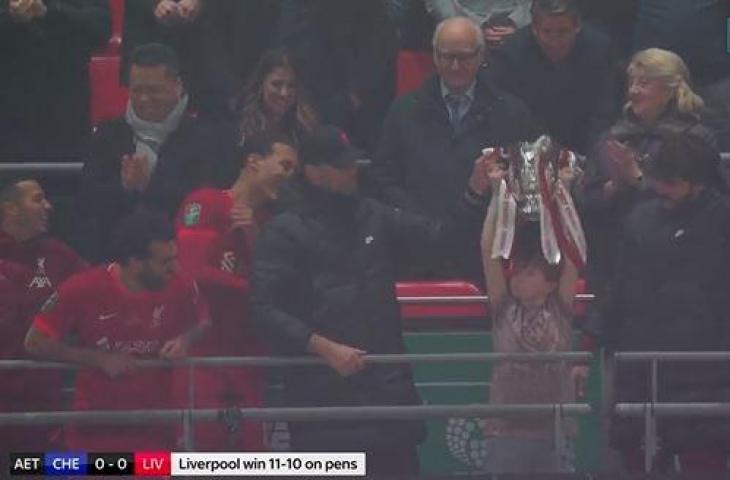 Potret seorang anak misterius turut angkat trofi Piala Liga Inggris bareng pemain Liverpool. (Twitter)