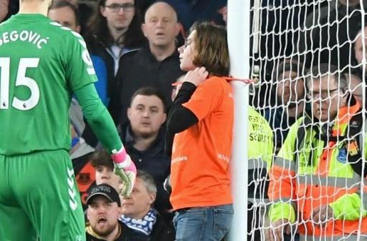 Potret pengunjuk rasa mengikat diri di tiang gawang di laga Everton vs Newcastle United dalam lanjutan Liga Inggris. (ANTHONY DEVLIN / AFP)