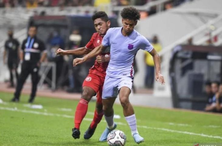 Pesepak bola Barcelona Jorge Javier Espinal Diaz (kanan) dibayangi pesepak bola Indonesia M Fathur Rahman di IYC 2021 di Jakarta International Stadium, Rabu (13/4/2022). (Antara/Hafiz Mubarak A/aww)