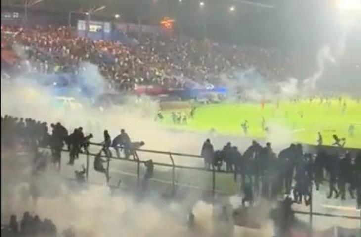 Polisi menembakkan gas air mata saat kericuhan suporter usai pertandingan Arema FC vs Persebaya Surabaya. (Twitter)