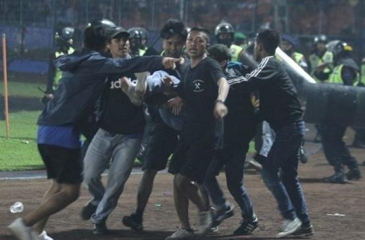 Sejumlah penonton membawa rekannya yang pingsan akibat sesak nafas terkena gas air mata yang ditembakkan aparat keamanan saat kericuhan usai pertandingan antara Arema FC vs Persebaya Surabaya di Stadion Kanjuruhan, Malang, Sabtu (1/10/2022). (ANTARA FOTO/Ari Bowo Sucipto/tom)