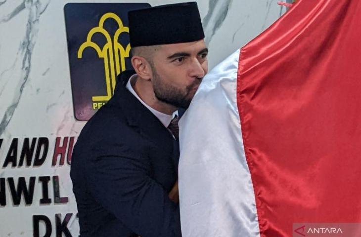 Pesepak bola Spanyol, Jordi Amat, mencium bendera Merah Putih di Kantor Wilayah Kementerian Hukum dan HAM DKI Jakarta, Jakarta, Kamis (17/11/2022), setelah dirinya resmi menjadi warga negara Indonesia. (ANTARA/Michael Siahaan)