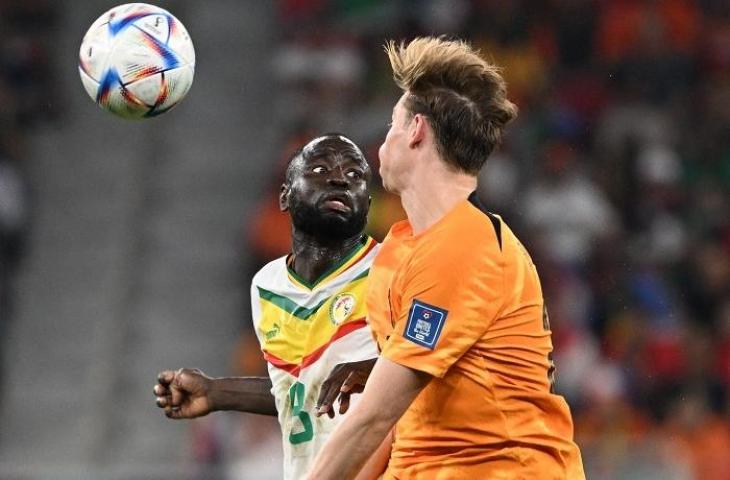 Pemain Senegal Cheikhou Kouyate berebut bola dengan penggawa Belanda Frenkie  De Jong di Piala Dunia 2022. (OZAN KOSE / AFP)