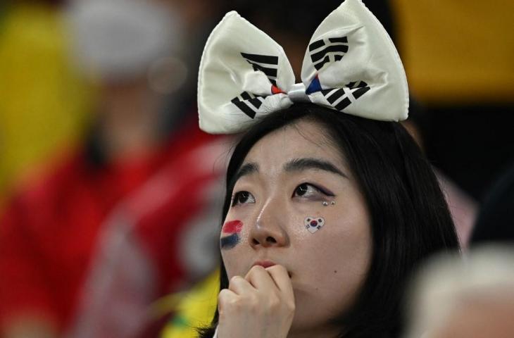 Seorang pendukung Korea Selatan terlihat sedih setelah timnya kalah 1-4 dari Brasil di babak 16 besar Piala Dunia 2022 di Stadion 974 di Doha pada 5 Desember 2022. (AFP/Manan Vatsyayana)