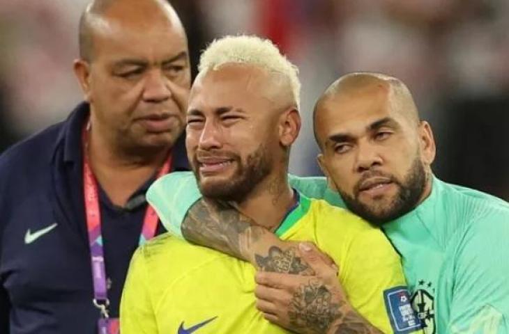 Penyerang Brasil Neymar menangis dan dihibur oleh bek Brasil Dani Alves setelah tim mereka kalah dalam diperempat final Piala Dunia 2022 antara Kroasia dan Brazil di Stadion Education City di Al-Rayyan, barat Doha, Qatar, Jumat (9/12/2022). [Adrian DENNIS/AFP]