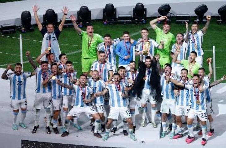 Penyerang Argentina, Lionel Messi, mengangkat Trofi Piala Dunia 2022 bersama pendukung usai mengalahkan Prancis di Stadion Lusail di Lusail, utara Doha pada 18 Desember 2022. (AFP)