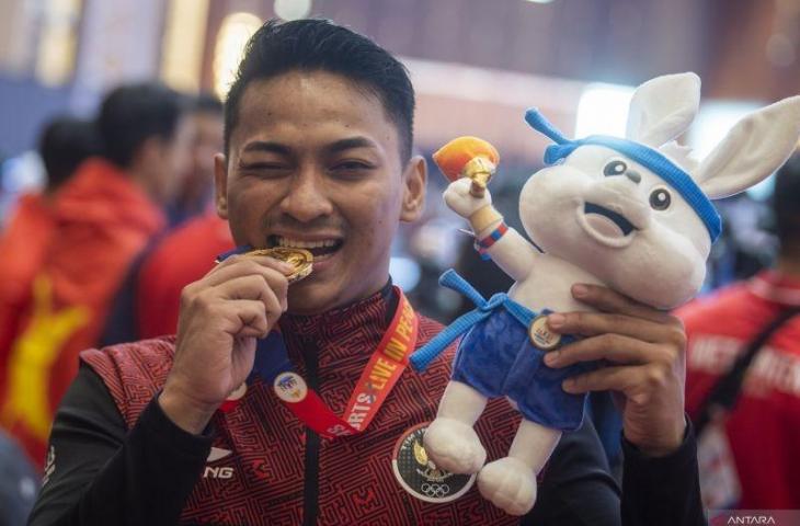 Atlet karate Indonesia Ahmad Zigi Zaresta Yuda menggigit medali emas usai pengalungan medali nomor kata individual putra SEA Games 2023 di Chroy Changvar International Convention & Exhibition Center, Phnom Penh, Kamboja, Sabtu (6/5/2023). . ANTARA FOTO/M Agung Rajasa/hp.