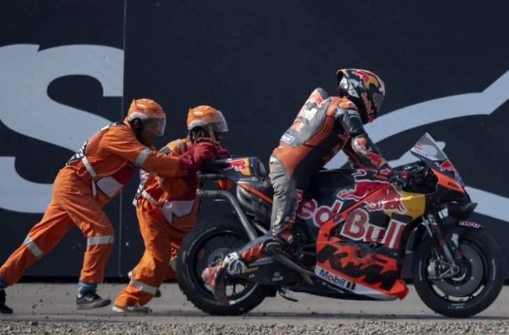 Pembalap Red Bull KTM Factory Racing Jack Miller menaiki motor dengan didorong marshal usai terjatuh pada sesi latihan bebas 2 MotoGP seri ke-15 di Pertamina Mandalika International Street Circuit. (ANTARA FOTO/WAHYU PUTRO A).