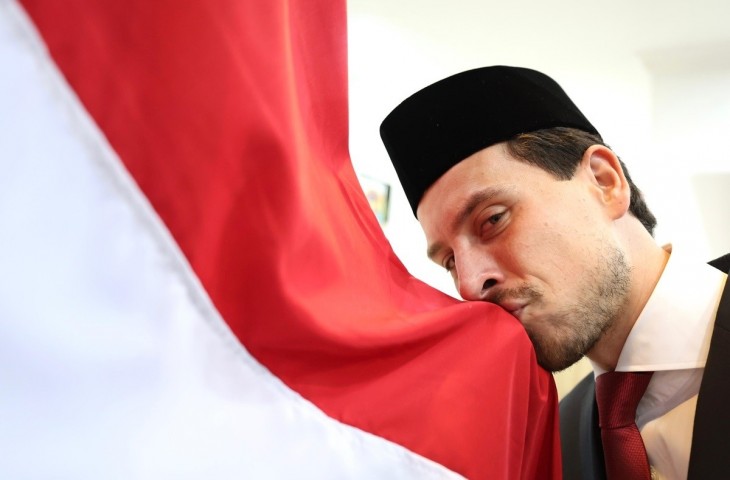 Pemain naturalisasi asal Belanda, Thom Haye mencium bendera Merah Putih usai mengambil sumpah kewarganegaraan di Kanwil Kemenkumham DKI Jakarta. (dok. PSSI).