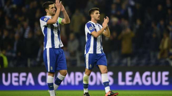 Dua pemain FC Porto, Ivan Marcano (kiri) dan Ruber Neves bertepuk tangan setelah timnya mengalahkan Leicester City dalam laga penyisihan Liga Champions di Grup G, Kamis (8/12) [AFP/Miguel Riopa].