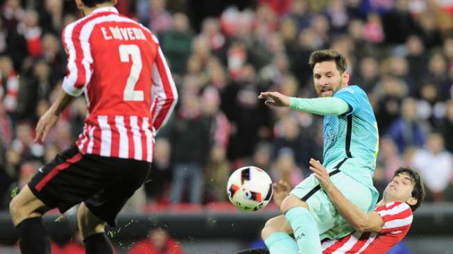 Striker Barcelona, Lionel Messi (tengah), mendapat tekel dari belakang oleh bek Athletic Bilbao, Mikel San Jose, saat kedua klub bertemu di leg pertama 16 Besar Piala Raja Spanyol, Kamis (5/1/2017) [AFP/Ander Gillenea]