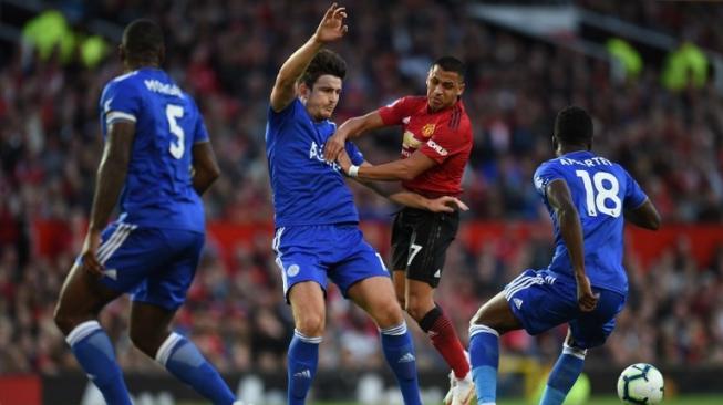 Bek Leicester City Harry Maguire (kiri) berebut bola dengan pemain Manchester United Alexis Sanchez saat laga di Old Trafford. Oli SCARFF / AFP