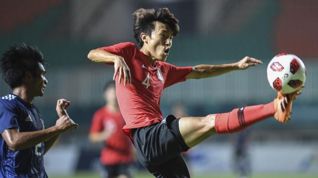 Pesepakbola Korsel, Jinya Kim (kanan), amankan bola dari kejaran pesepakbola Jepang, Yoichi Naganuma, pada pertandingan perebutan medali emas Asian Games 2018 di Stadion Pakansari,Bogor, Jawa Barat, Sabtu (1/9). [Antara/INASGOC/Dhemas Reviyanto]