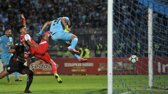 Gelandang Persela Lamongan Dendy Sulistyawan (kanan) menjebol gawang Arema FC yang berusaha dihadang pemain lawan, Alvin Tuasalamony (tengah), dalam lanjutan Liga 1 Indonesia yang berakhir 4-0 di Stadion Surajaya, Lamongan, Jawa Timur, Jumat (16/11/2018). [Antara/M Risyal Hidayat]