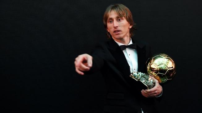 Gelandang Real Madrid dan Timnas Kroasia, Luka Modric memegang trofi Ballon d'Or 2018 pada acara penyerahan award yang dihelat di Grand Palais, Paris, Prancis, Selasa (4/12/2018) dini hari WIB. [FRANCK FIFE / AFP]