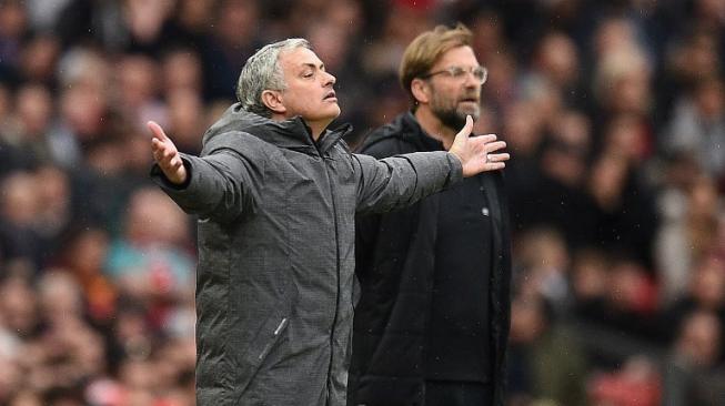 Reaksi Manajer Manchester United Jose Mourinho (kiri) dan manajer Liverpool Jurgen Klopp (kanan) di pinggir lapangan saat kedua tim bertarung di Liga Inggris. Oli SCARFF / AFP