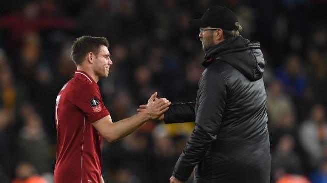 Pemain Liverpool James Milner berjabat tangan dengan manajer Jurgen Klopp usai timnya ditumbangkan Wolverhampton Wanderers di putaran ketiga Piala FA, Selasa (8/1/2019) [AFP]