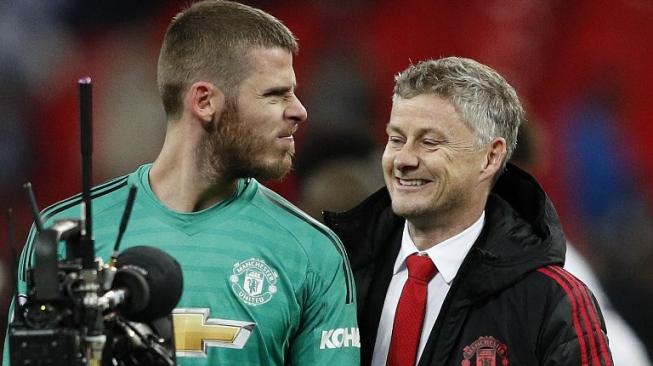 Kiper Manchester United David de Gea (kiri) bercanda dengan Ole Gunnar Solskjaer usai mengalahkan Tottenham Hotspur di Wembley Stadium. Adrian DENNIS / AFP 