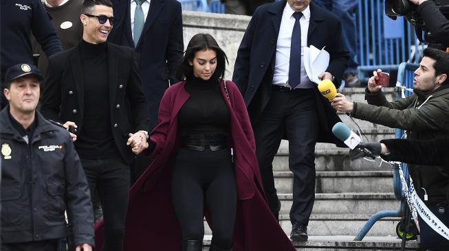 Pemain Juventus Cristiano Ronaldo bersama kekasihnya Georgina Rodriguez saat menghadiri sidang dugaan penggelapan pajak di Kota Madrid, Spanyol, Selasa (22/1). [PIERRE-PHILIPPE MARCOU / AFP]