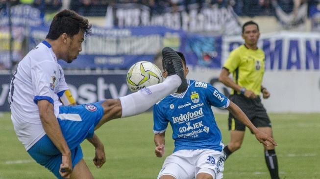 Pesepak bola Arema FC Hamka Hamzah (kiri) berebut bola dengan pemain Persib Bandung Erwin Ramdani (tengah) pada Laga pertama 16 besar Piala Indonesia di Stadion Si Jalak Harupat, Kabupaten Bandung, Jawa Barat, Senin (18/2/2019). [Antara/Novrian Arbi]