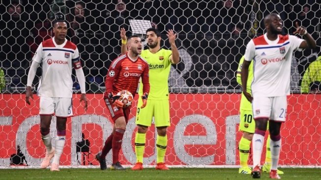 Kiper Lyon Anthony Lopes mengamankan bola dan striker Luis Suarez tampak kecewa gagal memanfaatkan peluang di leg pertama babak 16 besar Liga Champions di Groupama Stadium. FRANCK FIFE / AFP