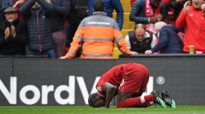 Striker Liverpool Sadio Mane sujud syukur setelah mencetak golnya ke gawang Chelsea di Anfield pada laga Liga Inggris. Paul ELLIS / AFP