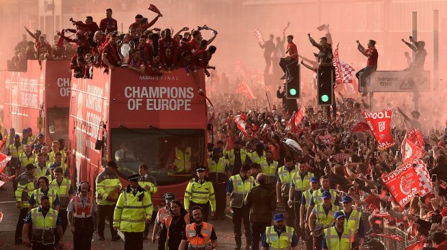 Para pemain Liverpool disambut ribuan penggemarnya saat parade juara Liga Champions dengan Bus terbuka di Liverpool, Inggris, Minggu (2/6). [Oli SCARFF / AFP]