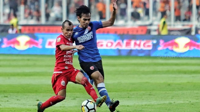 Pesepak bola Persija Jakarta Riko Simanjuntak berusaha melewatu pesepak bola PSM Makassar Rasyid Bakri dalam pertandingan Final Piala Indonesia 2018-2019 leg pertama di Stadion Utama Gelora Bung Karno (GBK), Senayan, Jakarta, Minggu (21/7). [Suara.com/Muhaimin A Untung]