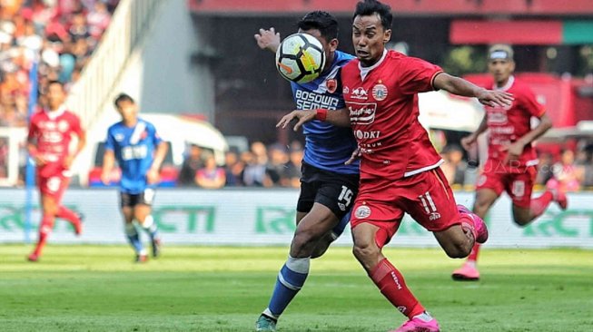 Pesepak bola Persija Jakarta Novri Setiawan berusaha melewati pesepak bola PSM Makassar Asnawi dalam pertandingan Final Piala Indonesia 2018-2019 leg pertama di Stadion Utama Gelora Bung Karno (GBK), Senayan, Jakarta, Minggu (21/7). [Suara.com/Muhaimin A Untung]