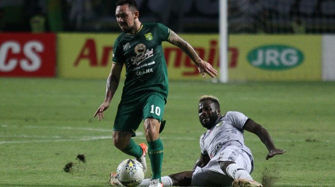 Pesepak bola Persebaya Damian Emanuel Lizio (kiri) melewati hadangan pesepak bola PS Tira Persikabo Parfait Louis Essengue (kanan) saat pertandingan Liga 1 2019 di Stadion Gelora Bung Tomo, Surabaya, Jawa Timur, Minggu (21/7/2019). ANTARA FOTO/Moch Asim