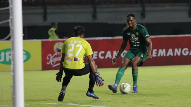 Penjaga gawang Persipura Jayapura Dede Sulaiman (kiri) menghadang pesepak bola Persebaya Amido Balde (kanan) pada pertandingan Liga 1 di Stadion Gelora Bung Tomo, Surabaya, Jawa Timur, Jumat (2/8/2019). Persebaya menang atas Persipura Jayapura dengan skor 1-0. ANTARA FOTO/Didik Suhartono