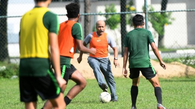 Pelatih timnas U-18 Fakhri Husaini (kedua kanan) bermain bola bersama pemainnya saat latihan di Lapangan Becamex Binh Duong, Vietnam, Kamis (15/8/2019). Indonesia lolos ke semifinal Piala AFF U-18 2019 di Vietnam sebagai juara grup A dengan poin 13 dari empat kemenangan dan sekali seri. ANTARA FOTO/Yusran Uccang/pras.