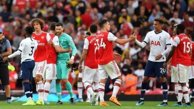 Para pemain Arsenal dan Tottenham Hotspur saling berjabat tangan usai laga Liga Inggris di Emirates Stadium, berakhir imbang 2-2. Ben STANSALL / AFP