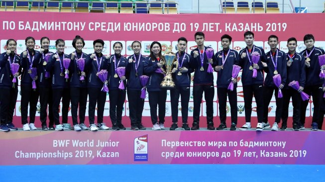 Manajer Tim Indonesia Susy Susanti (tengah) bersama skuat Tim Indonesia merayakan keberhasilan meraih Piala Suhandinata usai jadi kampiun di Kejuaraan Dunia Junior Bulutangkis 2019 di Kazan, Rusia, Sabtu (5/10/2019). [Humas PBSI]