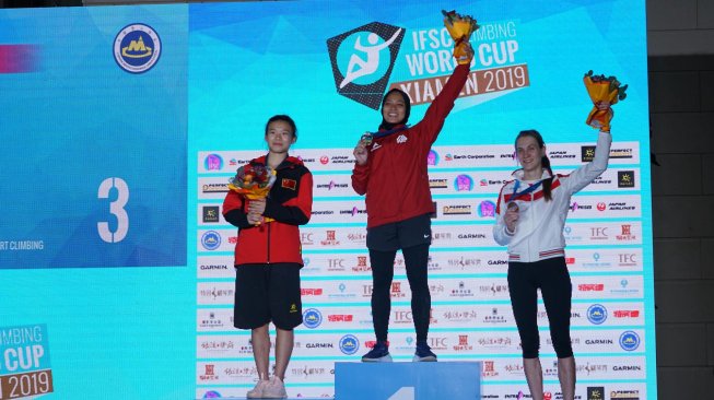 Atlet panjat tebing Indonesia Aries Susanti Rahayu (tengah) melakukan selebrasi usai memecahkan rekor kecepatan dunia saat final Kejuaraan Dunia Panjat Tebing di Xiamen, China, Sabtu (19/10). [ANTARA FOTO/Waspodo]