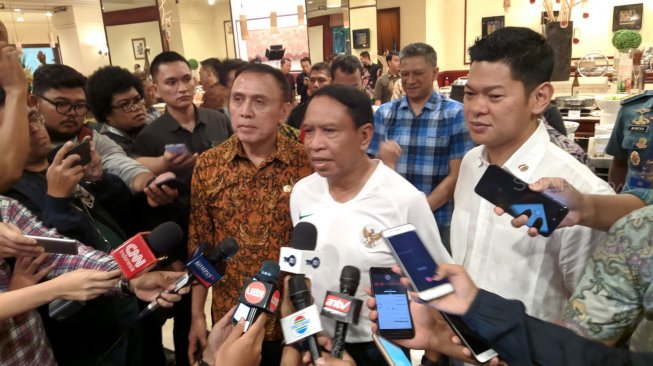 Menpora Zainudin Amali (tengah) didampingi Ketua Umum KOI Raja Sapta Oktohari (kanan) usai meninjau pemberian vaksinasi kepada kontingen Indonesia untuk SEA Games 2019 di Hotel Sultan, Senayan, Jakarta, Jumat (8/11/2019). [Suara.com/Arief Apriadi]