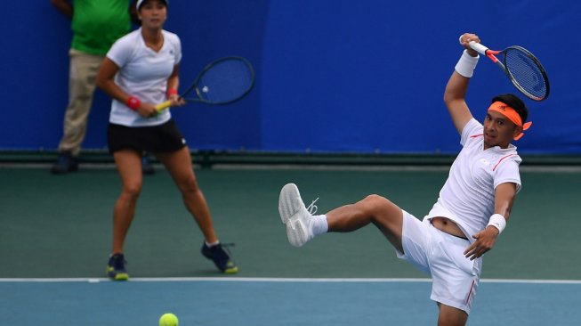 Petenis Indonesia Christopher Rungkat (kanan) dan Aldila Sutjiadi mengembalikan bola ke arah pasangan Thailand Sanchai Ratiwatana dan Tamarine Tanasugarn dalam babak final ganda campuran SEA Games 2019 di lapangan Rizal Memorial Tennis Center, Manila, Filipina, Sabtu (7/12). [Antara/Sigid Kurniawan]