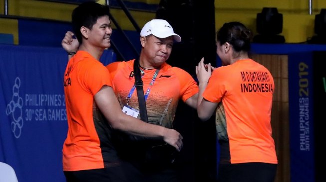 Pasangan ganda campuran Indonesia, Praveen Jordan/Melati Daeva Oktavianti, merayakan keberhasilan meraih medali emas SEA Games 2019 bersama sang pelatih, Richard Mainaky, usai mengalahkan wakil Malaysia, Goh Soon Huat/Lai Shevon Jemie, Senin (9/12). [Humas PBSI]