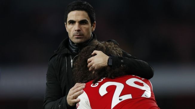 Manajer Arsenal, Mikel Arteta (kiri) menghibur gelandang Matteo Guendouzi usai laga Liga Inggris 2019/2020 kontra Chelsea di Emirates Stadium, London, Minggu (29/12/2019) malam WIB. [Adrian DENNIS / AFP]