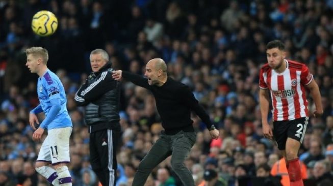 Manajer Manchester City Josep Guardiola memberi instruksi dari pinggir lapangan saat menghadapi Sheffield United, Minggu (29/12/2019). [AFP]