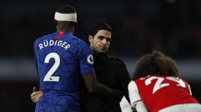 Manajer Arsenal Mikel Arteta bersalaman dengan pemain Chelsea Antonio Rudiger usai pertandingan Liga Inggris di Emirates Stadium, 29 Desember 2019. [AFP]