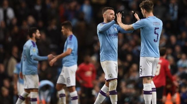 Para pemain Manchester City Nicolas Otamendi (kedua kanan) dan John Stones merayakan keberhasilan mereka lolos ke final Piala Liga Inggris usai menghadapi Manchester United di leg kedua semifinal di Etihad. Oli SCARFF / AFP