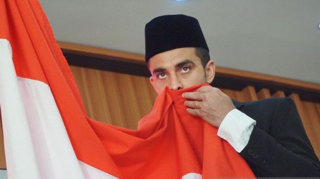 Otavio Dutra mencium bendera Merah Putih usai mengucapkan sumpah dan janji setia kepada NKRI saat prosesi menjadi warna Negara Indonesia di Kantor Wilayah Kementerian Hukum dan HAM Provinsi Jatim di Surabaya, Jumat (27/9/2019). (ANTARA Jatim/Naufal Ammar)