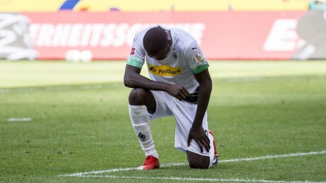 Penyerang Borussia Monchengladbach, Marcus Thuram menunjukkan gestur penghormatan untuk mendiang George Floyd, pada laga lanjutan Bundesliga 2019/2020 kontra Union Berlin, Minggu (31/5/2020) malam WIB. [Laman resmi Gladbach]