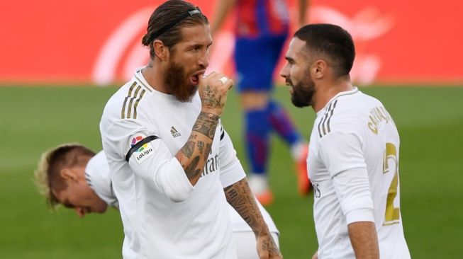 Gestur kapten Real Madrid, Sergio Ramos (kiri) usai membobol gawang Eibar pada laga Liga Spanyol 2019/2020 di Estadio Alfredo Di Stefano, Madrid, Senin (15/6/2020) dini hari WIB. [PIERRE-PHILIPPE MARCOU / AFP]