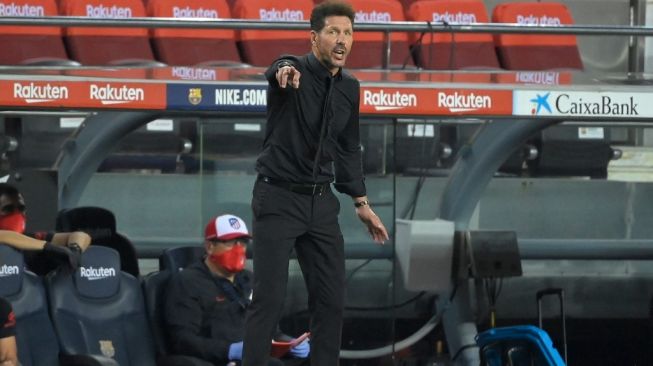 Pelatih Atletico Madrid, Diego Simeone memberikan instruksi pada laga Liga Spanyol 2019/2020 kontra Barcelona di Camp Nou, Rabu (1/7/2020) dini hari WIB. [Lluis GENE / AFP]