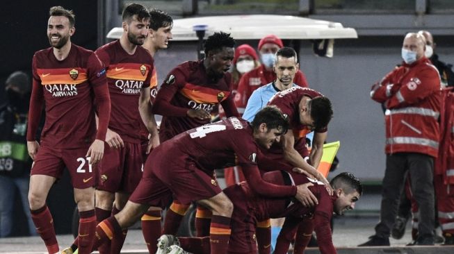 Bek AS Roma, Guanluca Mancini (bawah kanan) melakukan selebrasi dengan rekan-rekannya usai mencetak gol ketiga timnya saat menghadapi Shakhtar Donetsk dalam pertandingan leg pertama babak 16 besar Liga Europa di Stadion Olimpico, Roma, Jumat (12/3/2021) dini hari WIB. [Filippo MONTEFORTE / AFP].