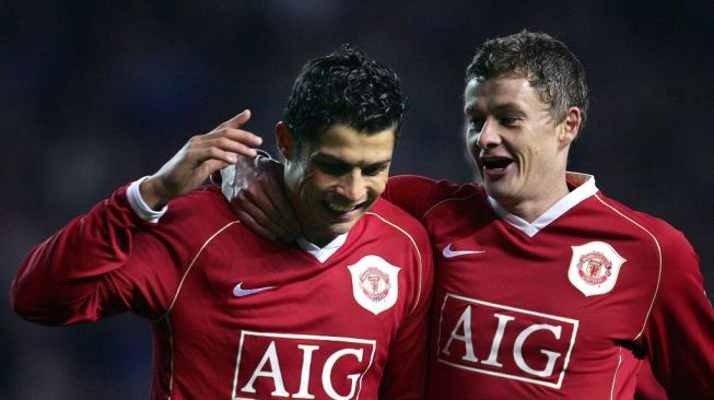 Striker Manchester United asal Portugal Cristiano Ronaldo melakukan selebrasi dengan Ole Gunnar Solskjaer setelah mencetak penalti rebound melawan Wigan Athletic selama pertandingan Liga Inggris di Old Trafford, 26 Desember 2006. AFP PHOTO / PAUL ELLIS Mobile