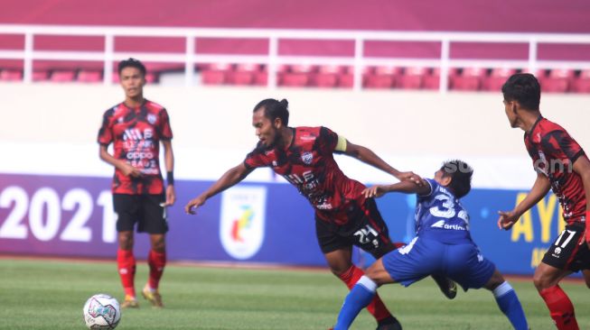 Pemain AHHA PS Pati, Ichsan Kurniawan diganjal striker PSCS Cilacap, Beny Ashar  dalam lanjutan Liga 2 Grup C di Stadion Manahan, Solo, Senin (4/10/2021). [Suara.com/Ronald Seger Prabowo]