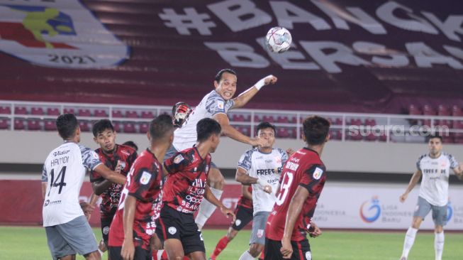 Bek Persis Solo, Rian Miziar berduel udara dalam situasi tendangan sudut melawan AHHA PS Pati di Stadion Manahan, Rabu (3/11/2021). [Suara.com/Ronald Seger Prabowo]